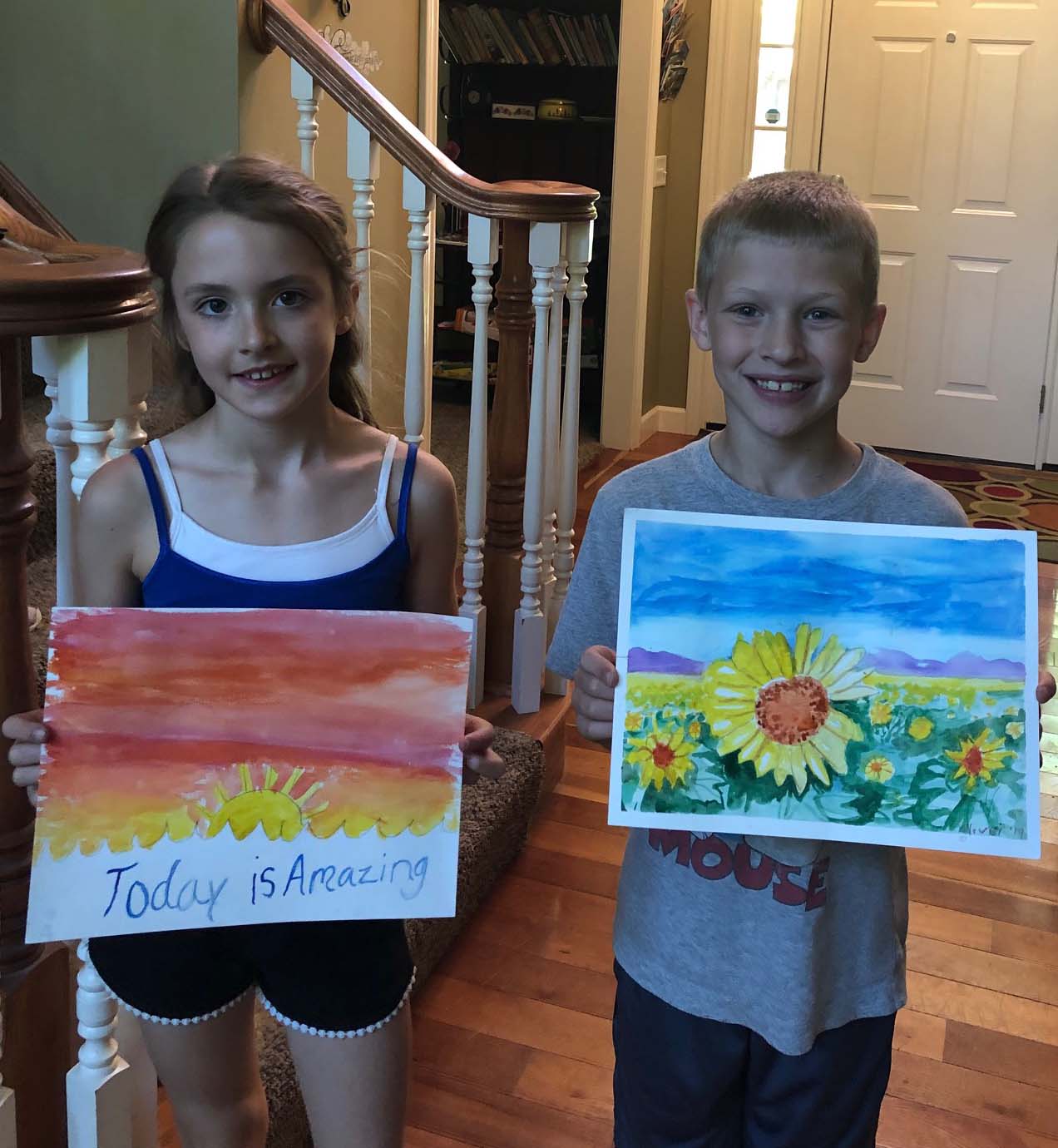 Image of two children with paintings of sunsets